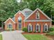 Stately two-story brick home with mature trees, manicured lawn, and a welcoming front entrance at 1440 Boundary Blvd, Suwanee, GA 30024