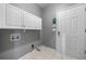 Efficient laundry room with ample storage, white cabinets, and a convenient access door at 1440 Boundary Blvd, Suwanee, GA 30024