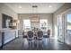 Elegant dining area with a wood table, fabric chairs, a modern chandelier, and large windows at 1741 Prospect Way, Conyers, GA 30094