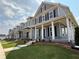 A row of well-maintained two-story townhomes featuring covered entrances, black shutters, and green lawns at 1741 Prospect Way, Conyers, GA 30094