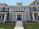 Charming two-story townhome featuring a covered entrance, double doors, and well-manicured landscaping at 1741 Prospect Way, Conyers, GA 30094