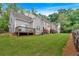 Wide view of a grassy townhome backyard with decks and privacy fences, with mature trees beyond at 2205 Hoskin Nw Ct # 9, Kennesaw, GA 30144