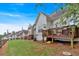 View of a backyard with a wooden deck and green grass surrounded by other houses and trees at 2205 Hoskin Nw Ct # 9, Kennesaw, GA 30144