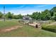 Long, angled view of the community playground surrounded by grass, bushes, and mature trees at 2205 Hoskin Nw Ct # 9, Kennesaw, GA 30144