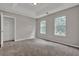 Well-lit bedroom with carpet flooring and two windows and closet providing ample storage at 3885 Riverview Chase Blf, Ellenwood, GA 30294