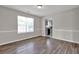 Bright dining room with hardwood floors, a window, and a glimpse of the modern kitchen in the background at 3885 Riverview Chase Blf, Ellenwood, GA 30294