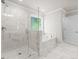 Modern bathroom featuring a glass shower and soaking tub, tiled in neutral colors at 741 Cams Crk, Mcdonough, GA 30253