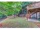 Large, well-maintained backyard with a fence, mature trees, and a covered patio at 4235 Crestwood Bend Cir, Buford, GA 30518