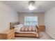 Bright bedroom with large window, a bed with decorative quilt, and matching nightstands at 4235 Crestwood Bend Cir, Buford, GA 30518