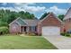 Charming brick home with manicured lawn, colorful flowerbeds, and a two-car garage at 4235 Crestwood Bend Cir, Buford, GA 30518