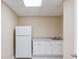 Basement kitchenette area with white cabinets, granite counters, and a full-sized refrigerator at 4235 Crestwood Bend Cir, Buford, GA 30518
