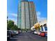 Modern high-rise apartment building with a parking lot in front and commercial space to the side at 4561 Olde Perimeter Way # 608, Dunwoody, GA 30346