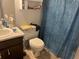 Bathroom with a dark brown vanity, standard toilet, and a blue shower curtain at 6354 Shannon Pkwy # 26C, Union City, GA 30291