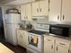 Kitchen with white cabinets, white countertops, and appliances including a stove, microwave, and refrigerator at 6354 Shannon Pkwy # 26C, Union City, GA 30291