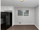 View of the kitchen offering white cabinets, black refrigerator, and window for natural light, complemented by new flooring at 1338 Georgia Ave, Atlanta, GA 30344