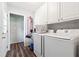 Bright laundry room with wooden floors, white cabinets and modern appliances at 160 Northside Ave, Dallas, GA 30157