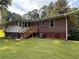 Rear view of the home showcasing an enclosed porch and access stairs to the backyard at 1791 Fairview Sw Dr, Austell, GA 30106