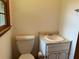 Small bathroom with toilet, sink, and marble countertop at 1791 Fairview Sw Dr, Austell, GA 30106