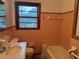 Bathroom featuring a toilet, bathtub, and single sink vanity with window at 1791 Fairview Sw Dr, Austell, GA 30106