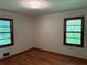 Cozy bedroom featuring hardwood floors, neutral walls, and natural light from two windows at 1791 Fairview Sw Dr, Austell, GA 30106