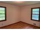 Bright bedroom featuring hardwood floors, neutral walls, and natural light from two windows at 1791 Fairview Sw Dr, Austell, GA 30106