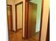 Hallway with hardwood floors and neutral-colored walls features multiple doorways at 1791 Fairview Sw Dr, Austell, GA 30106