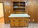 A wooden hutch with white countertop and multiple drawers provides storage in the kitchen area at 1791 Fairview Sw Dr, Austell, GA 30106