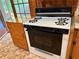 Close-up of a vintage-style gas range with a black oven door and wood cabinets at 1791 Fairview Sw Dr, Austell, GA 30106