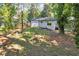 Backyard with a view of the white brick home, a well-kept lawn, and mature trees at 2595 Elkhorn Dr, Decatur, GA 30034