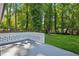 Spacious backyard with lush greenery, mature trees, and white brick terrace at 2595 Elkhorn Dr, Decatur, GA 30034