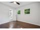 Hardwood floor bedroom with ceiling fan, window, and bathroom access at 2595 Elkhorn Dr, Decatur, GA 30034