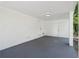 A covered carport with a painted white brick wall, grey floor, and overhead lighting at 2595 Elkhorn Dr, Decatur, GA 30034