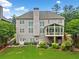 Grassy backyard featuring a spacious two-story home with a screened-in porch and manicured landscaping at 580 River Valley Dr, Dacula, GA 30019