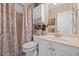 Cozy bathroom featuring a vanity with a white countertop, matching cabinetry, toilet, and shower with curtain at 580 River Valley Dr, Dacula, GA 30019