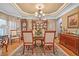 Formal dining room with hardwood floors, elegant chandelier, large dining table, and decorative china cabinet at 580 River Valley Dr, Dacula, GA 30019
