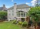 Two-story home exterior featuring a screened-in porch, landscaped backyard, and classic architectural details at 580 River Valley Dr, Dacula, GA 30019