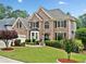A brick two-story home features manicured landscaping, lush lawn, and an attached two-car garage at 580 River Valley Dr, Dacula, GA 30019