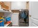 Functional laundry room with front load washer/dryer, upper cabinets and shelving unit for extra storage at 580 River Valley Dr, Dacula, GA 30019