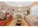 Elegant living room with hardwood floors, crystal chandelier, neutral-toned sofas, and decorative accents at 580 River Valley Dr, Dacula, GA 30019