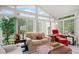 Relaxing sunroom featuring large windows with natural light and comfortable seating arrangements at 580 River Valley Dr, Dacula, GA 30019
