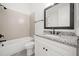 Bright bathroom featuring a bathtub with tile surround, granite countertop vanity, and modern fixtures at 2477 Bobbie Dr, Marietta, GA 30066