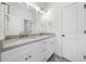 Elegant bathroom with double granite sink vanity, modern lighting, framed mirror, and sleek white finishes at 2477 Bobbie Dr, Marietta, GA 30066