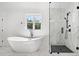 Modern bathroom with large window, soaking tub, separate glass-enclosed shower, and stylish marble floors at 2477 Bobbie Dr, Marietta, GA 30066