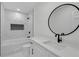 Elegant bathroom featuring marble tiling, a sleek vanity, and a modern round mirror at 4698 Fellsridge Dr, Stone Mountain, GA 30083