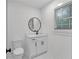 Updated bathroom with a white vanity, modern fixtures, and a round mirror at 4698 Fellsridge Dr, Stone Mountain, GA 30083