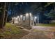 Nighttime view of brick home with updated landscaping and inviting entry at 4698 Fellsridge Dr, Stone Mountain, GA 30083