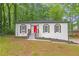 Charming, renovated brick ranch home with red front door and new landscaping at 4698 Fellsridge Dr, Stone Mountain, GA 30083