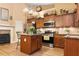 Charming kitchen boasts stainless steel appliances, a granite island, and classic wooden cabinetry at 221 Creekside Pass Pass, Canton, GA 30114
