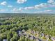 Expansive aerial view showing a neighborhood surrounded by a vast, lush forest under a blue sky at 2909 Everson Ridge Ct, Snellville, GA 30039