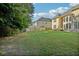 View of a large, grassy backyard with a wooden fence, mature trees, and patio furniture at 2909 Everson Ridge Ct, Snellville, GA 30039